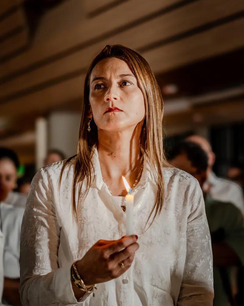 Una mujer en oración con su vela